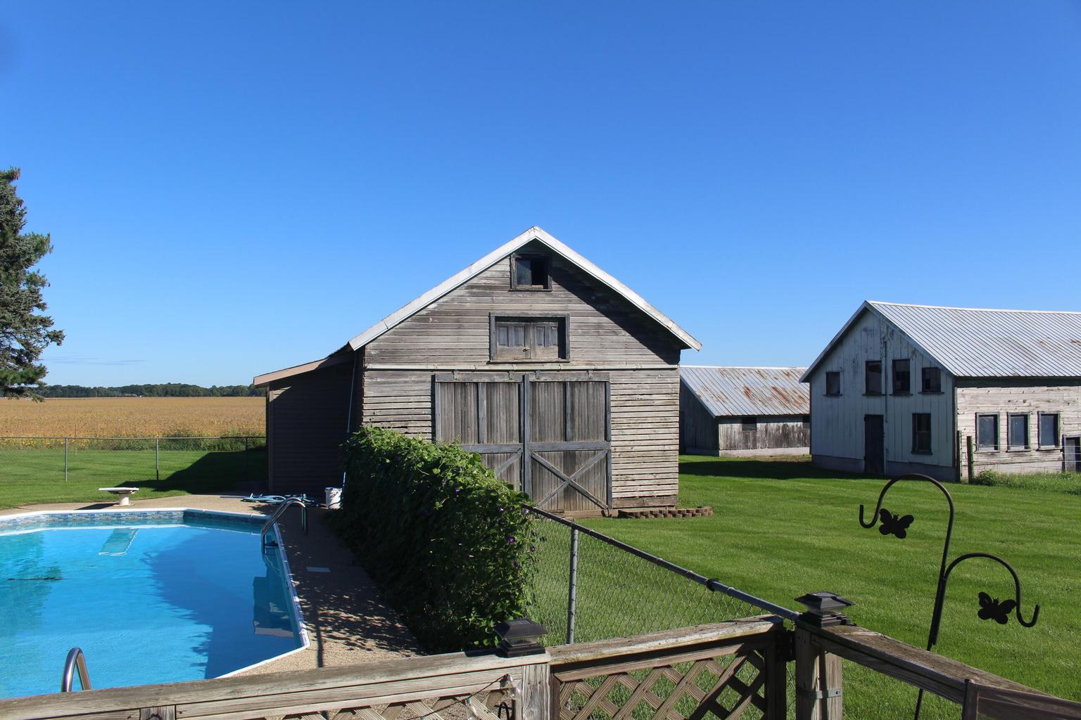 back yard with pool and outbuildings